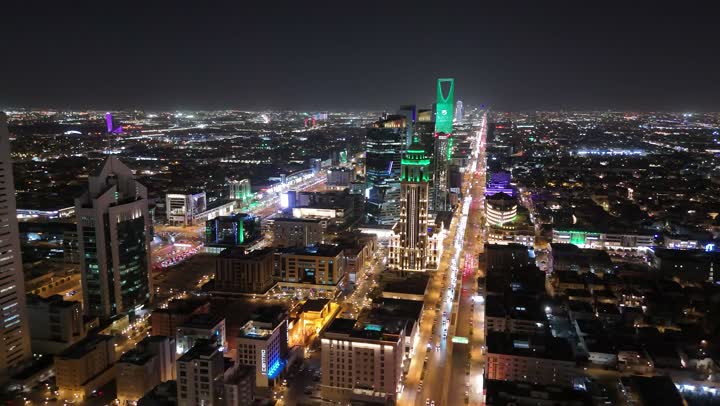 الشوارع المعبدة والطرقات، المنشأت التجارية والسكنية والمباني على الطراز الحديث، تصوير درون جوي لحركة مرور السيارات في شوارع العاصمة المضيئة ليلا، الاهتمام بالبنية التحتية في مدينة الرياض، الفن الهندسي المعماري للابراج وناطحات السحاب في المملكة العربية السعودية