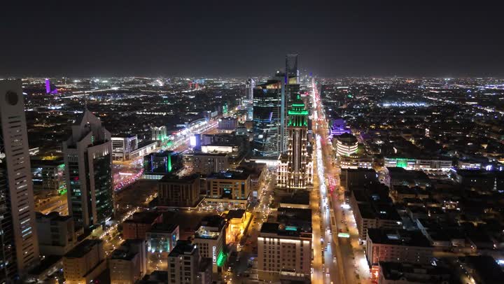 الشوارع المعبدة والطرقات، المنشأت التجارية والسكنية والمباني على الطراز الحديث، تصوير درون جوي لحركة مرور السيارات في شوارع العاصمة المضيئة ليلا، الاهتمام بالبنية التحتية في مدينة الرياض، الفن الهندسي المعماري للابراج وناطحات السحاب في المملكة العربية السعودية