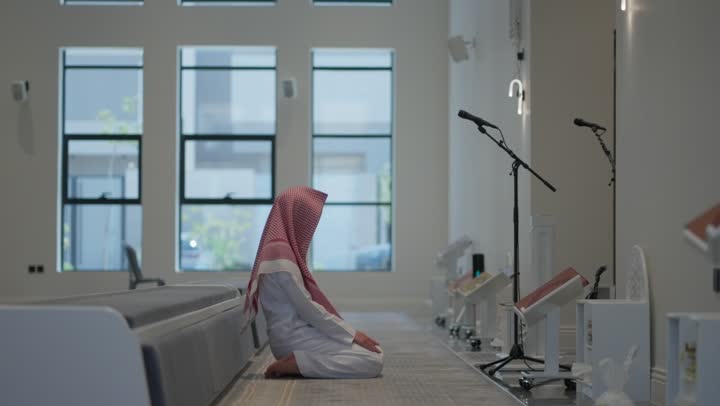 أداء فريضة الصلاه داخل المسجد، رجل عربي خليجي سعودي يرتدي الثوب التقليدي والشماغ يصلي في المصلى، تعابير وايماءات الخشوع في الصلاه، العبادة و التقرب الى الله