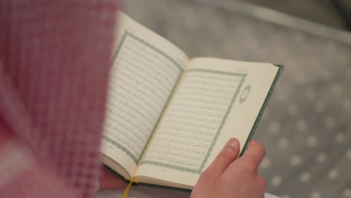 تلاوة وحفظ القرأن الكريم, العبادة و التقرب الى الله, الخلوة داخل بيت الله, رجل عربي خليجي سعودي مسلم يرتدي الشماغ والثوب التقليدي يجلس داخل المسجد و يقرأ من المصحف الشريف