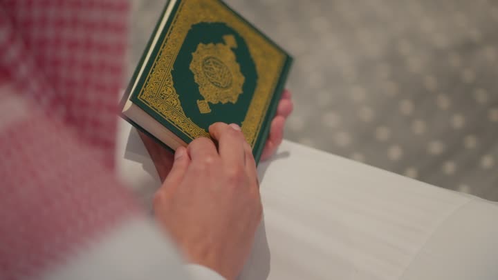 تلاوة وحفظ القرأن الكريم, العبادة و التقرب الى الله, الخلوة داخل بيت الله, رجل عربي خليجي سعودي مسلم يرتدي الشماغ والثوب التقليدي يجلس داخل المسجد و يقرأ من المصحف الشريف