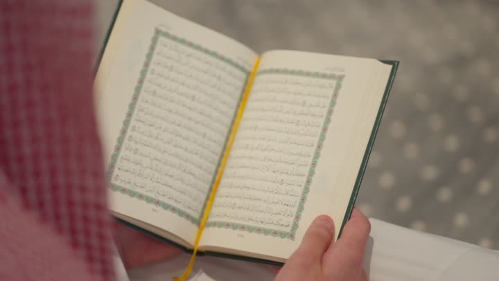 تلاوة وحفظ القرأن الكريم, العبادة و التقرب الى الله, الخلوة داخل بيت الله, رجل عربي خليجي سعودي مسلم يرتدي الشماغ والثوب التقليدي يجلس داخل المسجد و يقرأ من المصحف الشريف