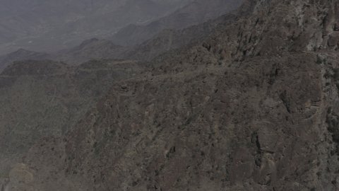 A famous tourist attraction that attracts tourists from all over the world, the mountainous environment in the Kingdom of Saudi Arabia, aerial drone photography of winding roads in the city of Al Baha, rock formations, mountains, peaks and heights in historical landmarks