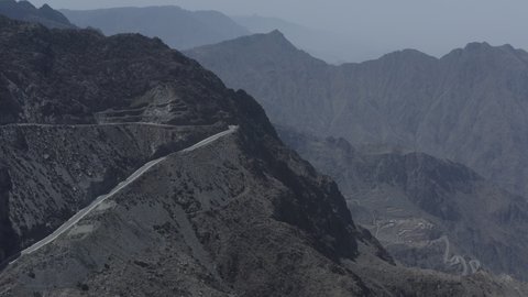 التكوينات والتشكيلات الصخرية والجبال والقمم والمرتفعات في المعالم التاريخية, مكان ومعلم سياحي مشهور، جذب واستقطاب السياح من كافة انحاء العالم، البيئة الجبلية في المملكة العربية السعودية, تصوير درون جوي لطرق متعرجة في مدينة الباحة