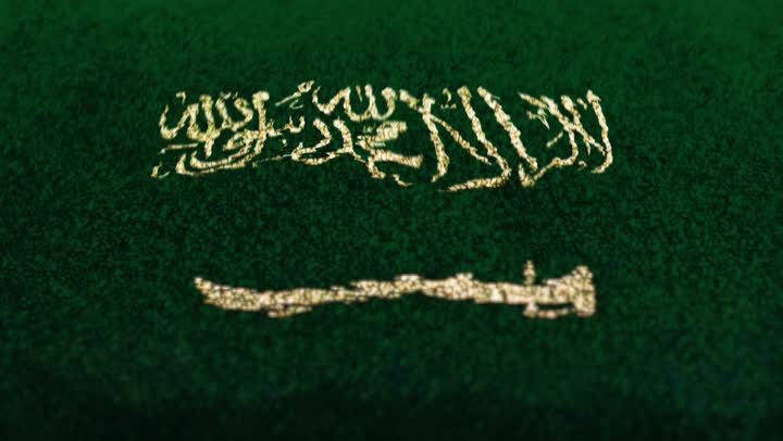 The flag of the Kingdom of Saudi Arabia in soft golden sand, commemorating Saudi National Day, September 23, celebrating national holidays and occasions, pride and honor in Saudi identity, the concept of love and belonging to the homeland