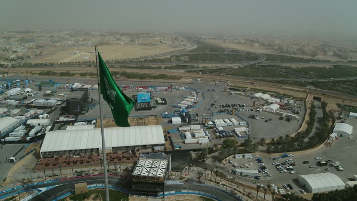 سارية العلم السعودي الأخضر المرفرف في الهواء في دوار الملك فيصل، الفخر والاعتزاز بالانتماء الى الوطن, المعالم المشهورة في مدينة أبها بمنطقة عسير جنوب غرب المملكة