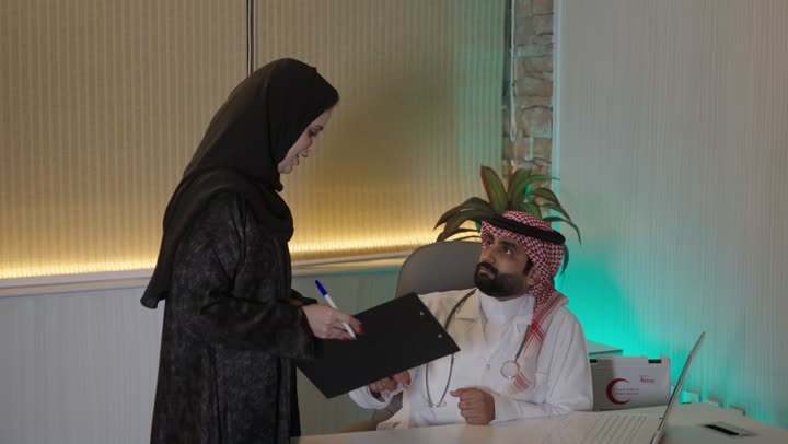 مفهوم الطب والرعاية الصحية، إدارة شؤون الأعمال عبر جهاز تقني حديث ومتطور، العمل فى القطاع الصحي، العمل على الحاسوب المحمول  ،طبيب عربي خليجي سعودي يرتدي المعطف الابيض والسماعه  يقوم باستخدام الحاسوب المحمول وتدوين الملاحظاات ، العيادة الطبية في السعودية
