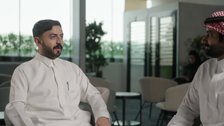 تبادل الخبرات والمعلومات لتحقيق الاهداف, الحوار و النقاش بين الزملاء، بيئة العمل المريحة في الشركات السعودية، موظفان عربيان خليجيان سعوديان يعملان في مكتبهم داخل مقر الشركة