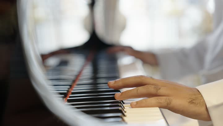 مواهب فنية وفنون موسيقية ، رجل عربي سعودي خليجي يرتدى الزي التقليدي يقوم بالعزف على آلة البيانو , آلات موسيقية