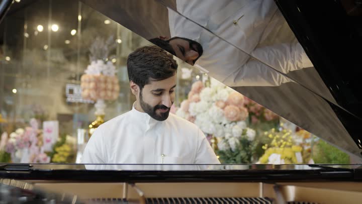 مواهب فنية وفنون موسيقية ، رجل عربي سعودي خليجي يرتدى الزي التقليدي يقوم بالعزف على آلة البيانو , آلات موسيقية