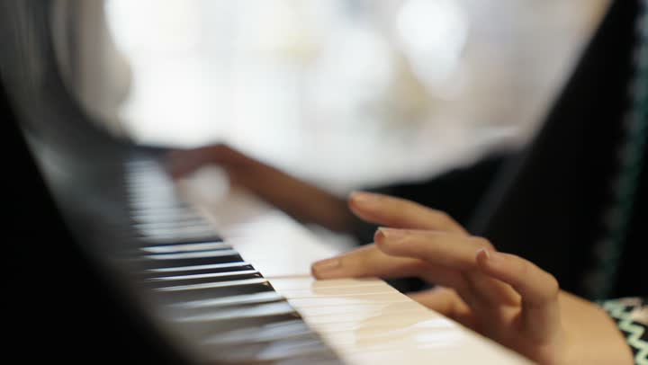 امراه عربية سعودية خليجية ترتدى العباءه والحجاب تقوم بالعزف على آلة البيانو , آلات موسيقية , مواهب فنية وفنون موسيقية .