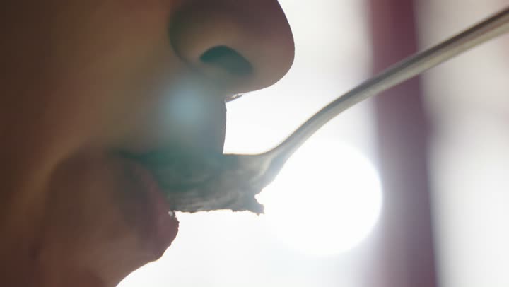 تصوير مقرب لامراه تقوم باكل قطعة من حلى كيك البراوني المزين بحبيبات الشوكولا ، وصفات وأطباق طعام لذيذة، مطاعم عربية خليجية سعودية، حلوى طازجة, حلويات ذات سعرات حراريه عاليه