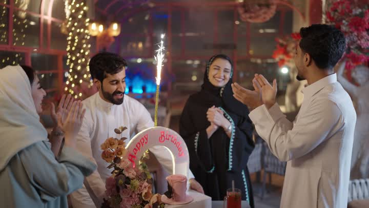 إيماءات السعادة والمفاجأة والفرح، زينة الأعياد والمناسبات السعيدة، رجل عربى خليجي سعودي يقوم بالاحتفال بعيد ميلاد زوجته في إحدى المطاعم السعودية، قضاء وقت ممتع مع الأهل والأصدقاء، كعكة عيد ميلاد