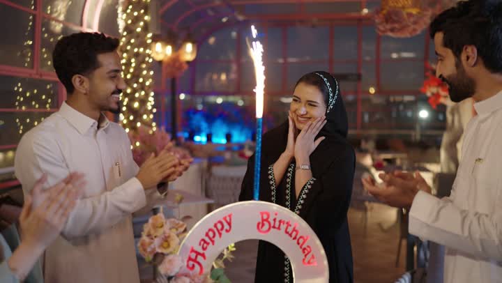 إيماءات السعادة والمفاجأة والفرح، زينة الأعياد والمناسبات السعيدة، رجل عربى خليجي سعودي يقوم بالاحتفال بعيد ميلاد زوجته في إحدى المطاعم السعودية، قضاء وقت ممتع مع الأهل والأصدقاء، كعكة عيد ميلاد