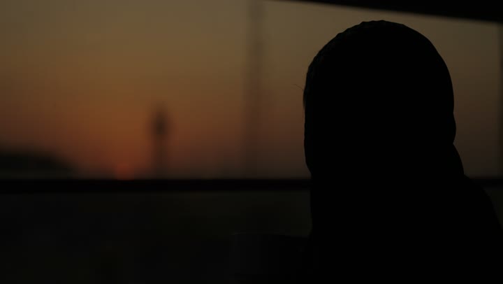 جلسة هادئة مطلة على الميناء البحري وقت غروب الشمس ، تعديل المزاج بشرب الكافيين, الاستمتاع باحتساء المشروب المفضل، سيدة عربية خليجية سعودية ترتدي العباءة تمسك بيدها كوب من القهوة