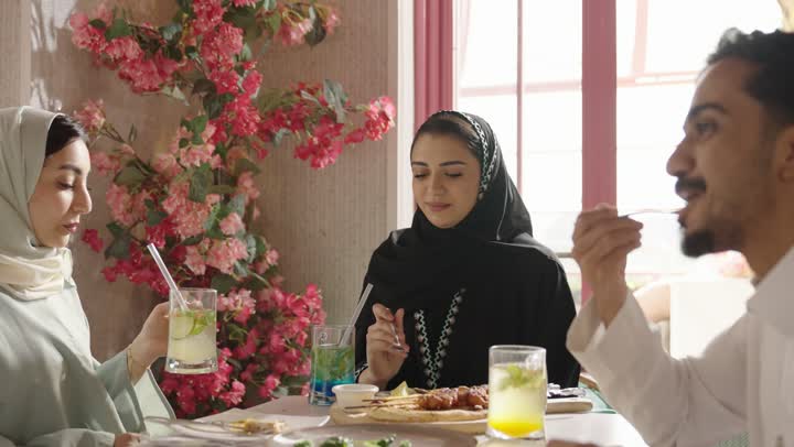 سفره مليئه بأنواع الاطعمه والمشروبات الباردة, مجموعه اصدقاء عرب خليجيون سعوديون يتناولون الطعام في المطعم, ,  الاستمتاع بتناول طعام صحي ولذيذ, عطلة نهاية الاسبوع