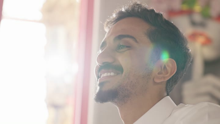 ايماءات السعادة والسرور اثناء تناول المشروبات الباردة، شاب عربي خليجي سعودي يرتدي الزي التقليدي يمسك بيده كوب من العصير الطبيعي فى احدى مطاعم السعودية، تحسين مستويات الطاقة والتركيز