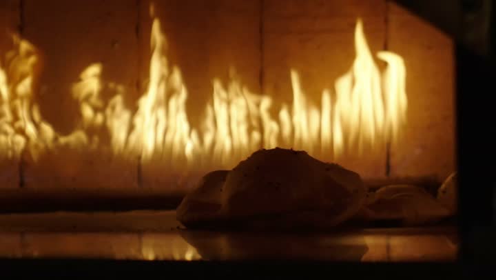A close-up image of traditional Arabic bread loaves inside the oven, the bread spread out in the popular Arabic oven, bakeries and ovens in the Kingdom of Saudi Arabia, fresh hot baked goods.