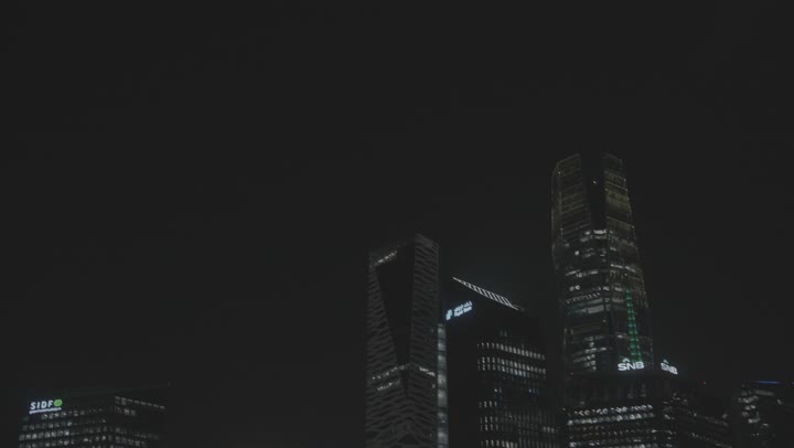 A nighttime exterior shot of KAFD, the King Abdullah Financial Center (KAFD) in Riyadh, Saudi Arabia, featuring financial and economic towers and architectural facilities, tourism in Saudi Arabia, a stunning nighttime view of the financial center.