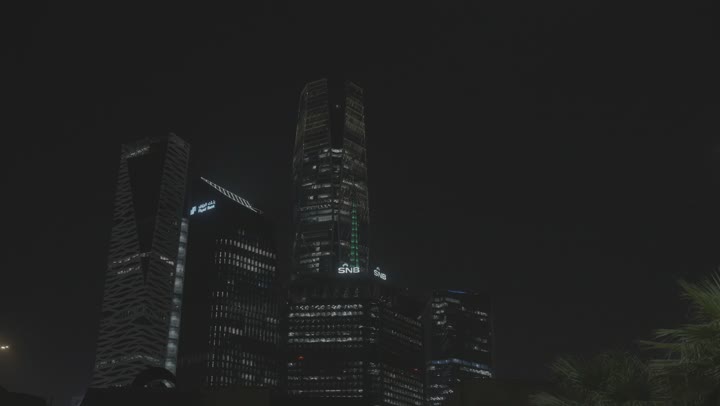 A nighttime exterior shot of KAFD, the King Abdullah Financial Center (KAFD) in Riyadh, Saudi Arabia, featuring financial and economic towers and architectural facilities, tourism in Saudi Arabia, a stunning nighttime view of the financial center.