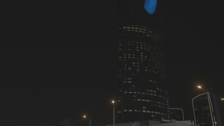 Night traffic in Riyadh near the Kingdom Tower, the Kingdom Tower building in the city of Riyadh at night, the architectural engineering art of building towers and skyscrapers in a modern style, famous landmarks and tourist attractions in the Kingdom of Saudi Arabia.