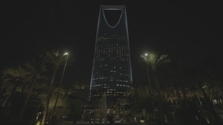 The exterior entrance of the Kingdom Tower, the Kingdom Tower building in Riyadh at night, the architectural engineering art of building towers and skyscrapers in a modern style, famous landmarks and tourist attractions in the Kingdom of Saudi Arabia.