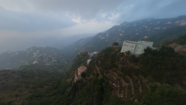 A stunning panoramic view through a drone lens, the highlands and mountain ranges, the rock formations and structures in the city of Jazan, the green plants cultivated on the mountains of Jazan, the distinctive landscapes, the famous places and tourist attractions in the Kingdom of Saudi Arabia.