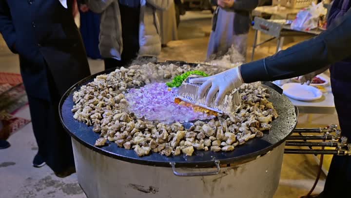 Preparing food on the griddle, cooking a variety of different Saudi dishes and beverages, close-up shots of a Gulf Arab Saudi chef preparing food for serving.