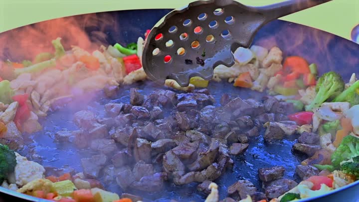 Preparing food on the griddle, cooking a variety of different Saudi dishes and beverages, close-up shots of a Gulf Arab Saudi chef preparing food for serving.