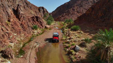 المناطق الطبيعية الصحراوية في المملكة العربية السعودية، التجول الصحراء العربية الواسعة، تصوير درون جوي لسيارة الدفع الرباعي جيب القديمة وسط الوحل