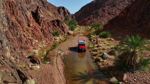 المناطق الطبيعية الصحراوية في المملكة العربية السعودية، التجول الصحراء العربية الواسعة، تصوير درون جوي لسيارة الدفع الرباعي جيب القديمة وسط الوحل