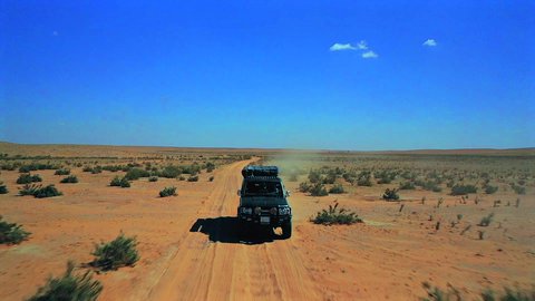  التجول في الصحراء العربية الواسعة، تصوير درون جوي لسيارة الدفع الرباعي جيب القديمة وسط الرمال والبر، المناطق الطبيعية الصحراوية في المملكة العربية السعودية