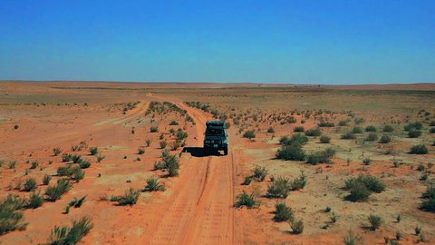  التجول في الصحراء العربية الواسعة، تصوير درون جوي لسيارة الدفع الرباعي جيب القديمة وسط الرمال والبر، المناطق الطبيعية الصحراوية في المملكة العربية السعودية