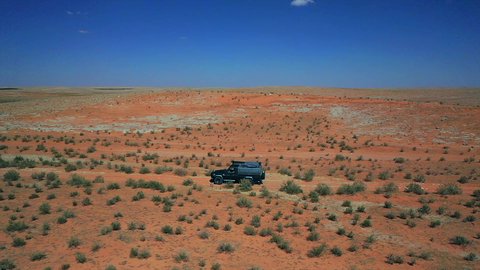  التجول في الصحراء العربية الواسعة، تصوير درون جوي لسيارة الدفع الرباعي جيب القديمة وسط الرمال والبر، المناطق الطبيعية الصحراوية في المملكة العربية السعودية