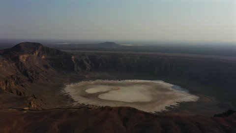 Rock formations and formations in natural areas, aerial drone photography of volcanic lava on mountain slopes, the crater of Al-Waaba volcano (a clay quarry) in the city of Taif in the Kingdom of Saudi Arabia, famous landmarks and tourist places.