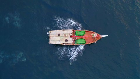 Fishing profession, vertical overhead drone photography of an old wooden fishing boat in the middle of the Red Sea, the environment, marine nature and fish wealth, Saudi national products and local wealth.