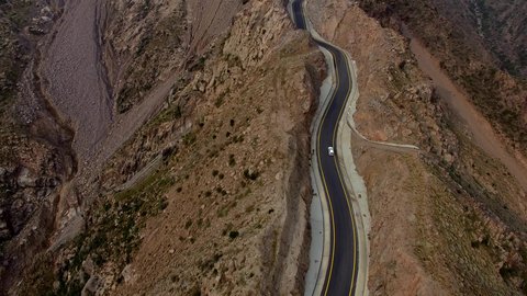 Traffic on a winding mountain pass, natural areas and historical tourist attractions in Asir, drone footage of the Sinana Pass road, foggy weather, desert landscape and mountainous heights in the Kingdom of Saudi Arabia