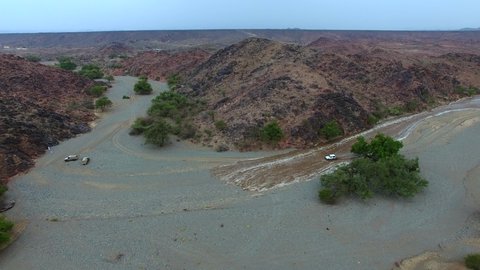 Floods in Bisha Valley in Asir, famous landmarks and tourist attractions, the distinctive natural landscapes of the Kingdom of Saudi Arabia, rainwater collecting in rocky valleys, green plants on the mountain slopes and foothills