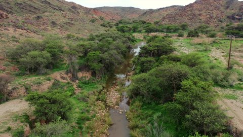 Drone photography of Wadi Jawf Al-Ashwat in Sarat Ubaidah, natural tourist attractions in the Kingdom of Saudi Arabia, rock formations and formations, green plants growing on hills and mountain heights in the Kingdom of Saudi Arabia, places that attract tourists from all over the world.