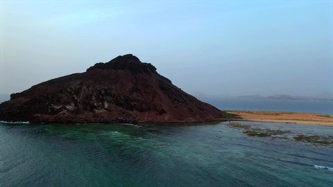Tourist attractions in the Kingdom of Saudi Arabia, aerial drone photography of Jabal Kadmbel Island in Asir, calm sea waves on the Red Sea coast, mountain peaks and heights during the day
