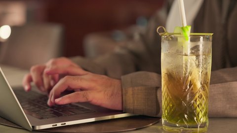 مفهوم ادخال البيانات، النقر على لوحة المفاتيح، صناعة المحتويات النصية، تصوير مقرب ليد رجل عربي خليجي اماراتي يستخدم  الحاسوب المحمول، الكتابة على جهازاللابتوب، دمج التكنولوجيا الحديثة بالحياة العملية، الاستمتاع بتناول المشروبات