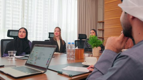 الاحترافية والتفاني في الانجاز، شرح العمليات والصفقات التجارية، التفاهم والتعاون بين الزملاء لتحقيق أهداف الشركة, نقاشات خاصة بالعمل, استخدام الحاسوب المحمول، اجتماع عمل مع موظفين عرب خليجيين اماراتيين مع رجال أعمال أجانب في غرفة الاجتماعات، ضمان فهم واضح للأعمال