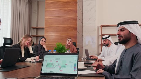 المناقشة وتبادل الافكار، عرض المخططات والمشاريع التجارية، اجتماع عمل بين موظفين عرب خليجيين اماراتيين مع رجال أعمال أجانب في غرفة الاجتماعات، بيئة العمل المريحة في الشركات الاماراتية, استخدام الأجهزة التقنية الحديثة في المكاتب، إنجاز المهام العملية عبر جهاز الحاسوب