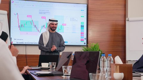 بيئة العمل المريحة في الشركات الاماراتية, إنجاز المهام عبر جهاز الحاسوب، عرض البيانات الاحصائية على الشاشة، الاتفاق على المشاريع التجارية، اجتماع عمل بين موظفين عرب خليجيين اماراتيين مع رجال أعمال أجانب في غرفة الاجتماعات، استخدام الأجهزة التقنية الحديثة في المكاتب