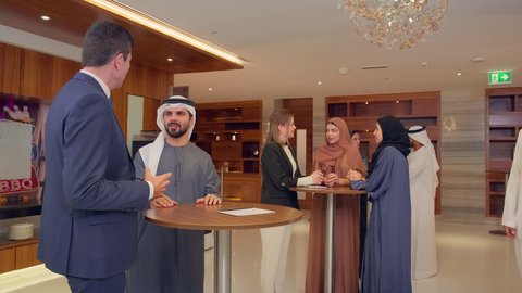 Signing new business deals, agreeing on commercial projects, a meeting of a team of Arab Gulf Emiratis with a foreign delegation in a luxurious conference hall, discussion and exchange of ideas among businessmen, a business exhibition in the United Arab Emirates with representatives.