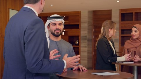 الاتفاق على المشاريع التجارية، اجتماع فريق عمل عرب خليجيين اماراتيين مع وفد اجنبي في قاعة مؤتمرات فخمة، المناقشة وتبادل الافكار بين رجال الأعمال، معرض أعمال في الامارات العربية المتحدة مع المندوبين، عقد صفقات عمل جديدة