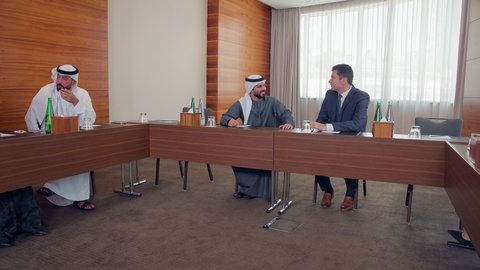 Discussion and exchange of ideas among businessmen, delivering speeches in conference halls, a meeting of a team of Emirati Gulf Arabs with a foreign delegation in a luxurious conference hall, a business exhibition in the United Arab Emirates with delegates, concluding new business deals.