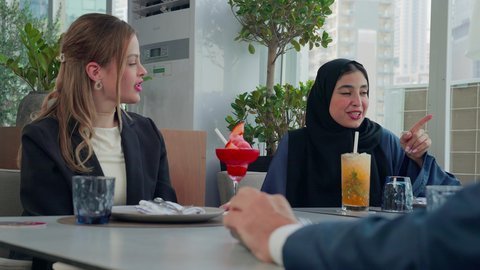 مناقشة مهام العمل في المطعم, المذاق الطيب للمأكولات والمشروبات، بناء علاقات اجتماعية ناجحة, اجتماع عمل في مكان خارج مقر الشركة, مشاركة الأوقات الممتعة, تصوير مقرب لمجموعة من الأصدقاء الاجانب والعرب خليجيين إماراتيين يجلسون على طاولة في إحدى المطاعم في الإمارات
