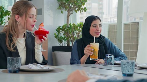 جلسة وناسة وتعارف، المذاق الطيب للمأكولات والمشروبات، بناء علاقات اجتماعية ناجحة, اجتماع عمل في مكان خارج مقر الشركة, مشاركة الأوقات الممتعة, تصوير مقرب لمجموعة من الأصدقاء الاجانب والعرب خليجيين إماراتيين يجلسون على طاولة في إحدى المطاعم في الإمارات
