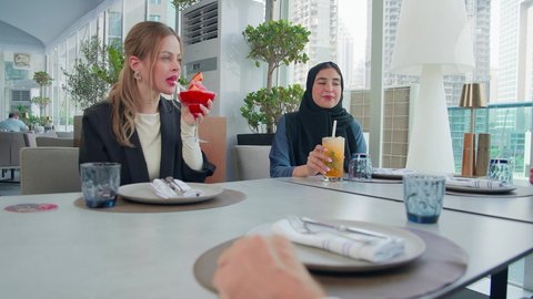 شرب سموزي فراولة والمشروبات الباردة، إيماءات السعادة والسرور، بناء علاقات اجتماعية ناجحة, اجتماع عمل في مكان خارج مقر الشركة, مشاركة الأوقات الممتعة, تصوير مقرب لمجموعة من الأصدقاء الاجانب والعرب خليجيين إماراتيين يجلسون على طاولة في إحدى المطاعم في الإمارات